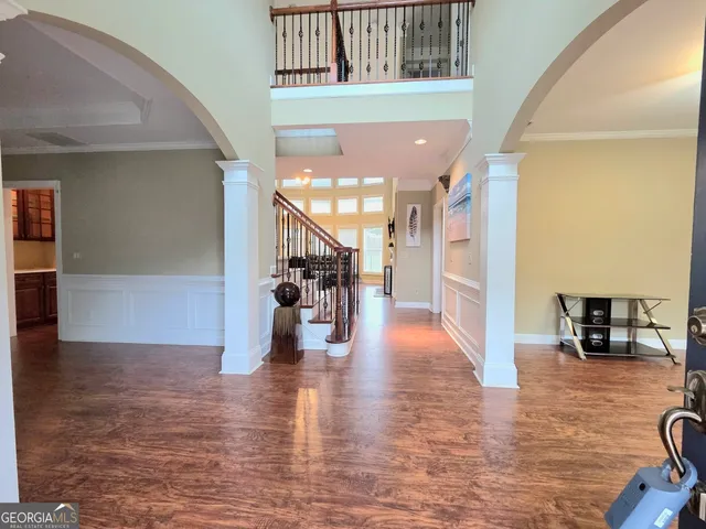 a view of a living room with kitchen view and wooden floor