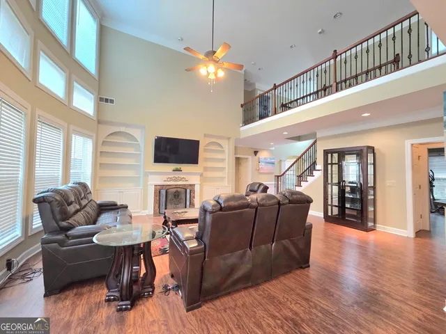 a living room with furniture a flat screen tv and wooden floor