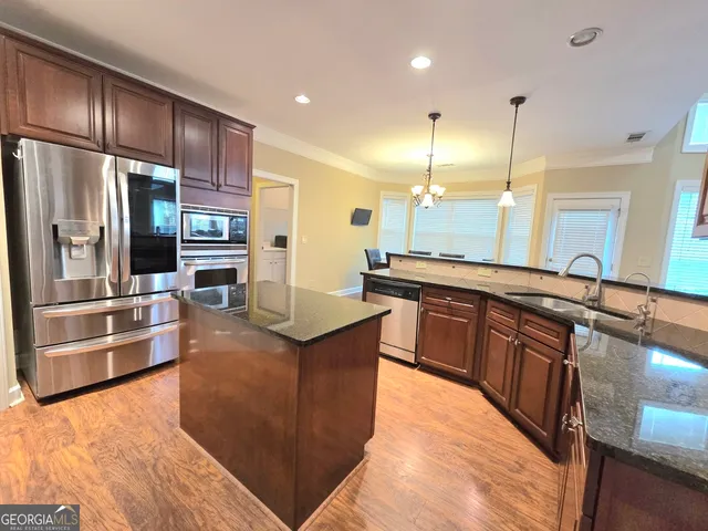 a large kitchen with stainless steel appliances kitchen island granite countertop a large counter top cabinets and stainless steel appliances