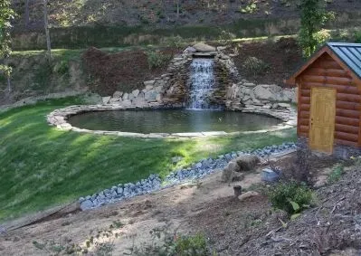 a view of a water pond with green field