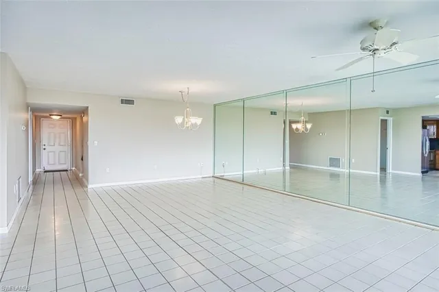 an empty room with wooden floor and mirror