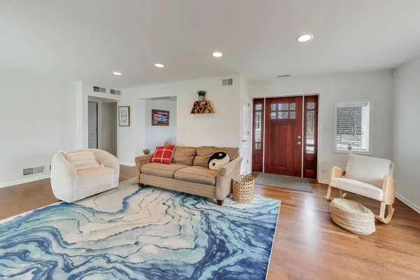a living room with furniture and a wooden floor