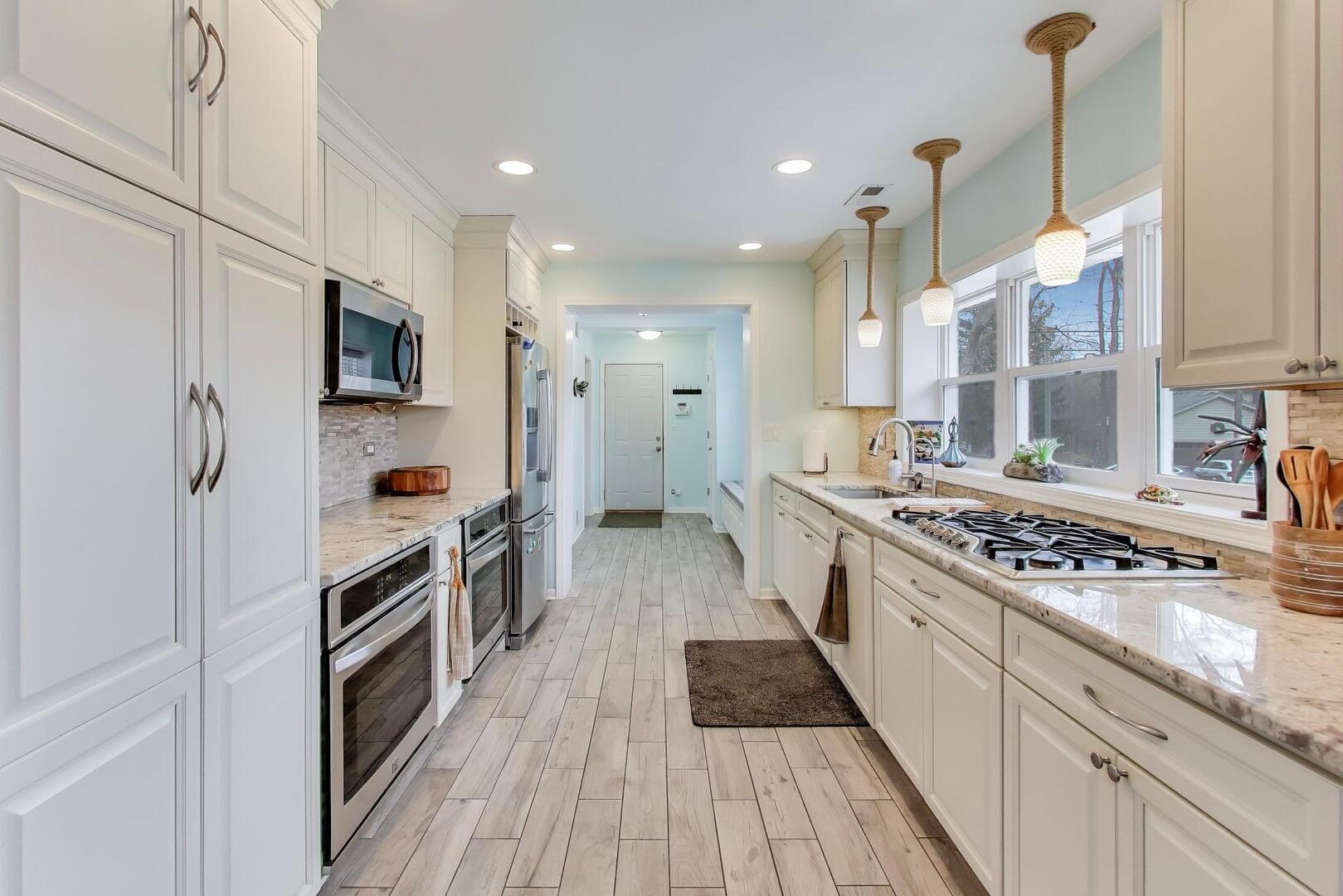 1127 Timber Trails Road Downers Grove, IL 60516 - Photo 10 of 30 a kitchen with stainless steel appliances a stove top oven a sink a refrigerator and cabinets