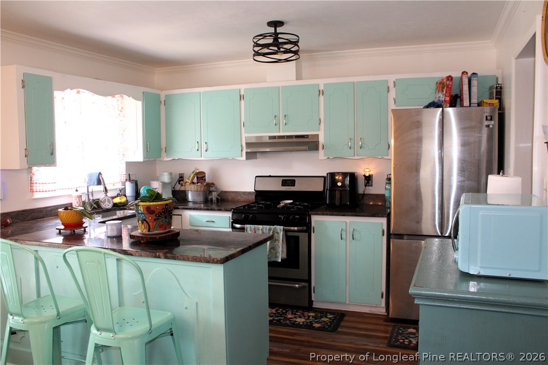 2038 Dunn Road Eastover, NC 28312 - Photo 6 of 29 a kitchen with a refrigerator and a stove top oven