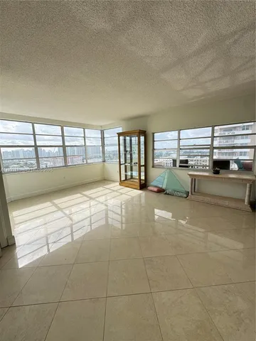 a living room with furniture a flat screen tv and a large window