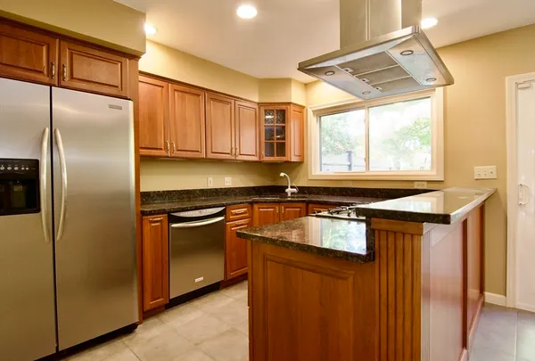 a kitchen with stainless steel appliances granite countertop a refrigerator and a sink