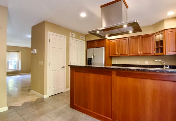a view of kitchen with stainless steel appliances granite countertop cabinets and a refrigerator