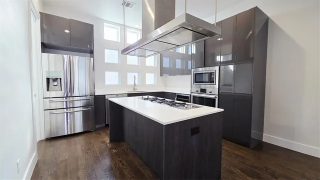 a kitchen with stainless steel appliances granite countertop a refrigerator a sink and a stove