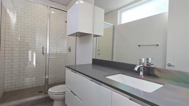 a bathroom with a sink a toilet and shower