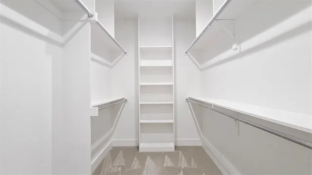a view of walk in closet with empty racks