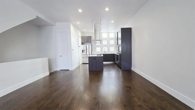 a view of a big room with wooden floor and windows