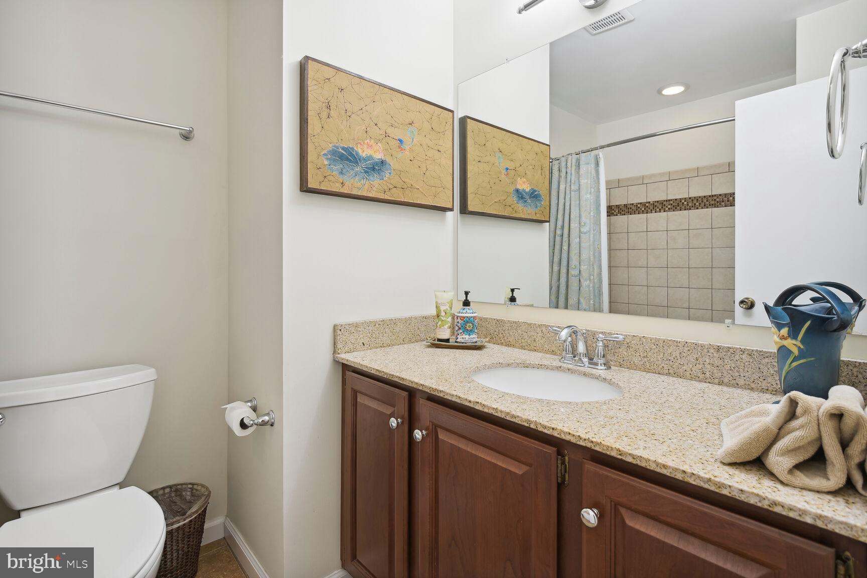 5210 Russett Road Rockville, MD 20853 - Photo 12 of 28 a bathroom with a granite countertop sink mirror vanity and toilet