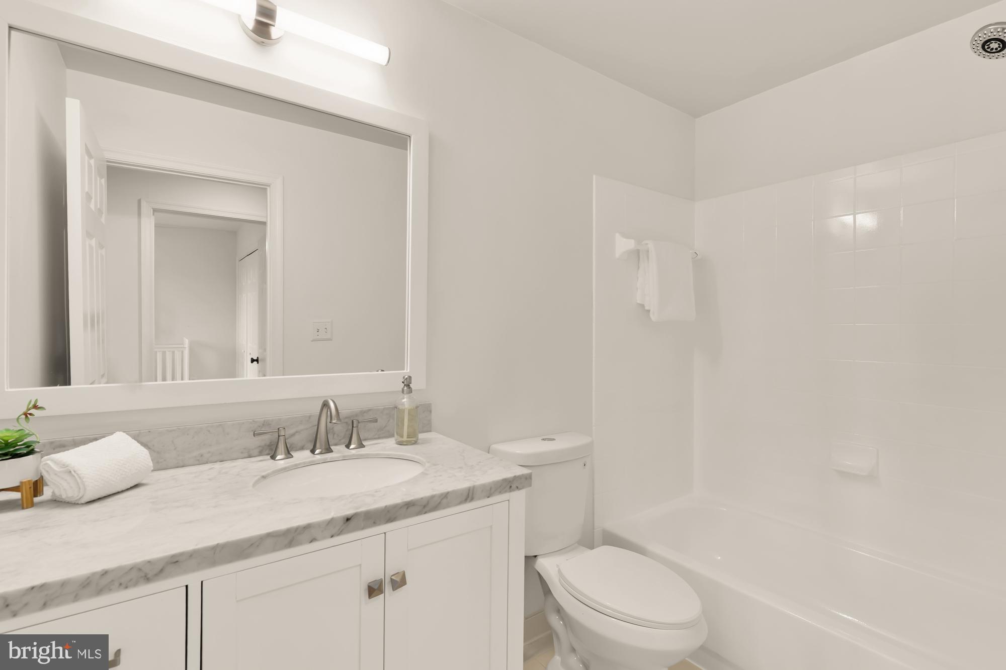 255 14th Street Southeast, Unit A Washington, DC 20003 - Photo 23 of 28 a bathroom with a granite countertop sink a toilet and a mirror