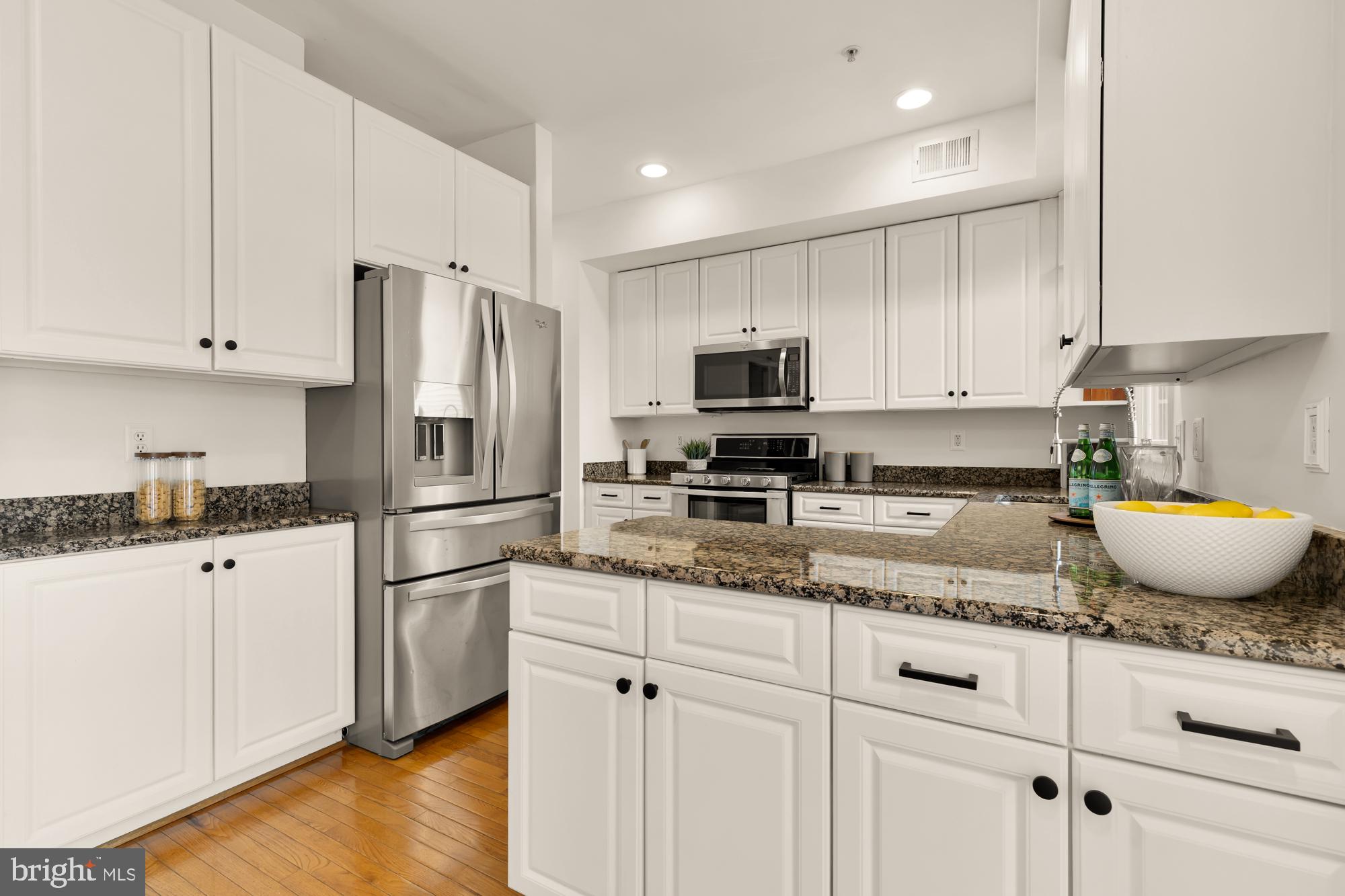 255 14th Street Southeast, Unit A Washington, DC 20003 - Photo 5 of 28 a kitchen with granite countertop a sink stainless steel appliances and white cabinets