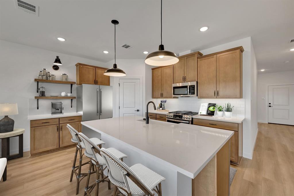 1424 Elliott Road Howe, TX 75459 - Photo 9 of 28 a kitchen with stainless steel appliances granite countertop a stove top oven a sink a stove a dining table and chairs with wooden floor