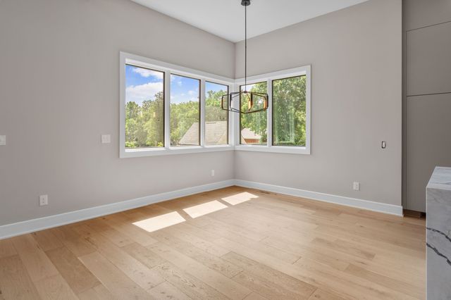 a large kitchen with stainless steel appliances granite countertop a lot of cabinets and wooden floor