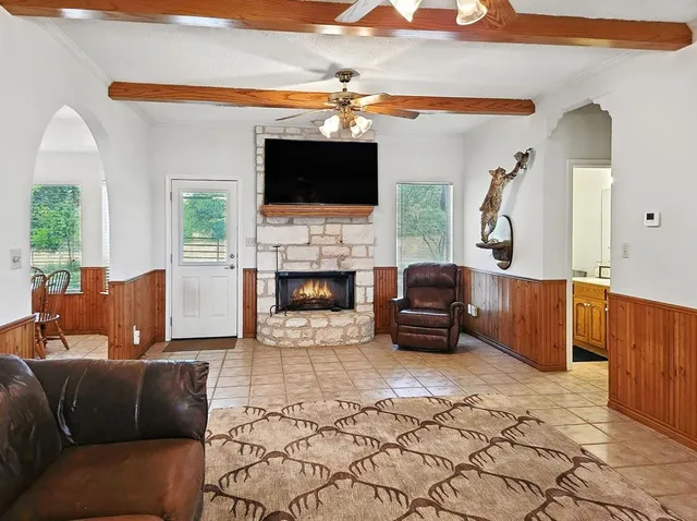 a living room with furniture a flat screen tv and a fireplace