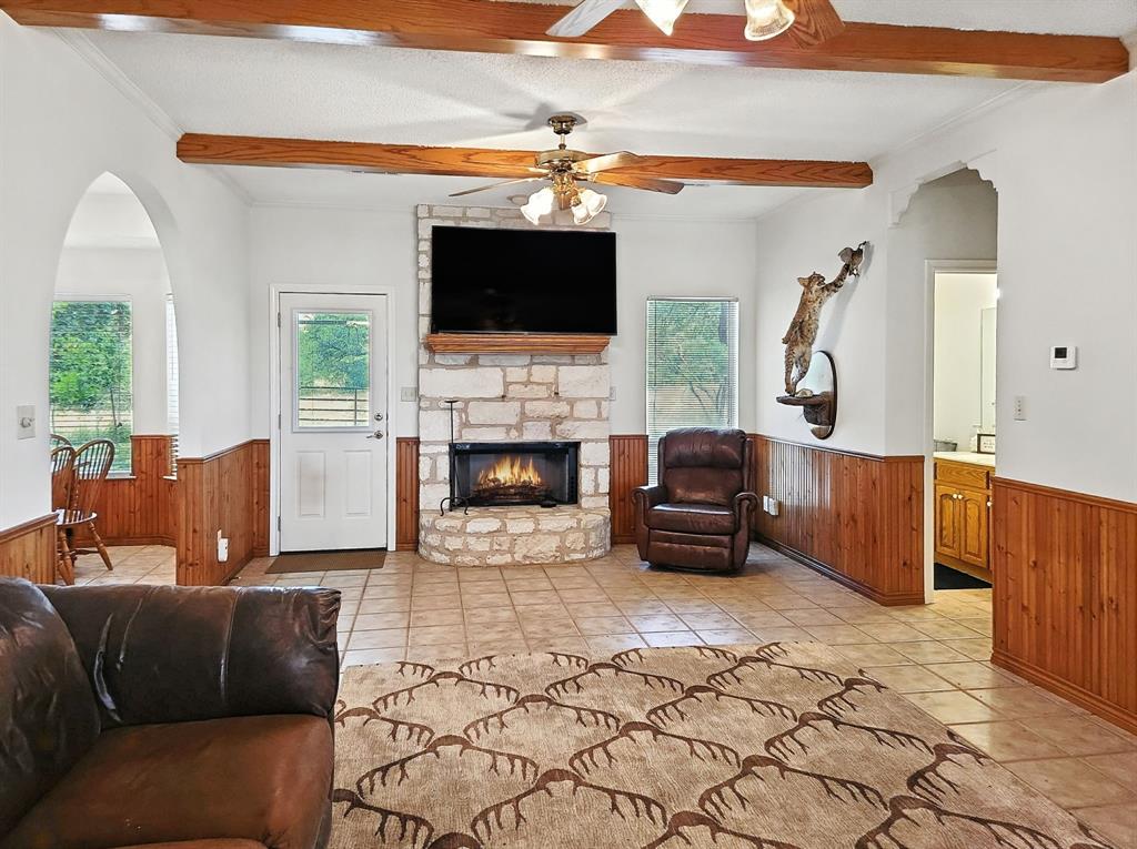 895 Pr 202 / Highway Hamilton, TX 76531 - Photo 18 of 40 a living room with furniture a flat screen tv and a fireplace