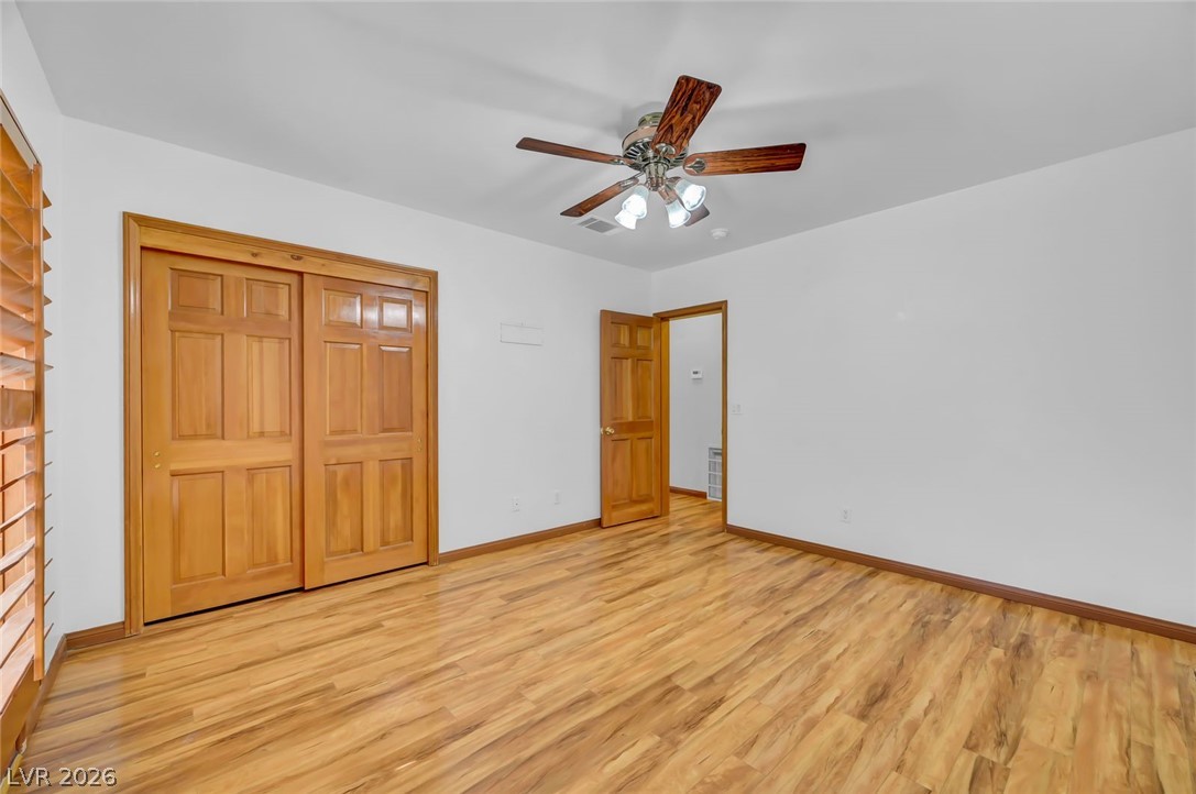 640 North Racetrack Road Henderson, NV 89015 - Photo 35 of 65 Rich wood flooring grounds this well-lit bedroom featuring a practical closet and ceiling fan.