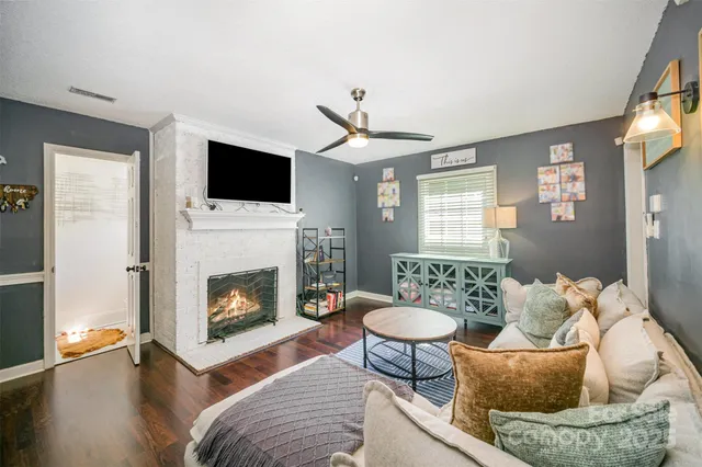 a living room with furniture a flat screen tv and a fireplace