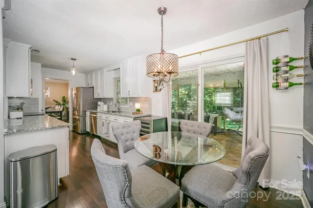 a dining room with furniture a chandelier and wooden floor