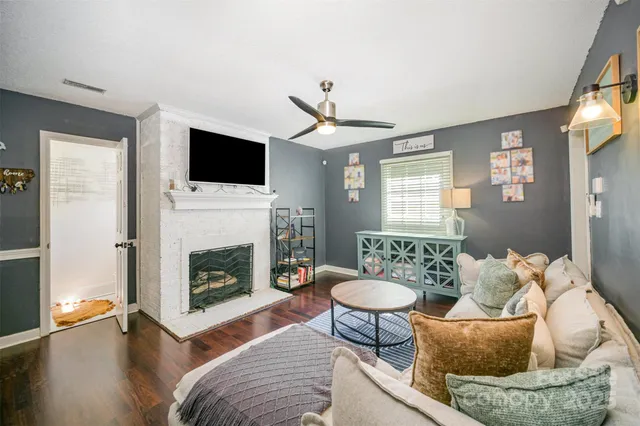 a living room with furniture a flat screen tv and a fireplace
