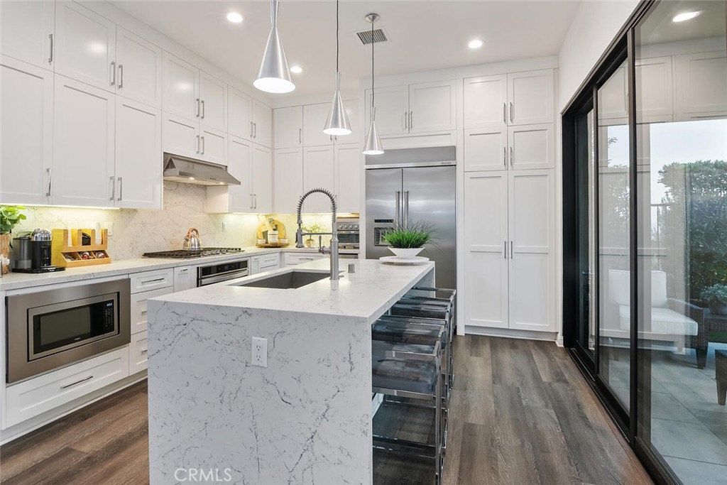 20732 Beech Circle Porter Ranch, CA 91326 - Photo 15 of 72 a kitchen with kitchen island granite countertop a stove a sink and a refrigerator with wooden floor