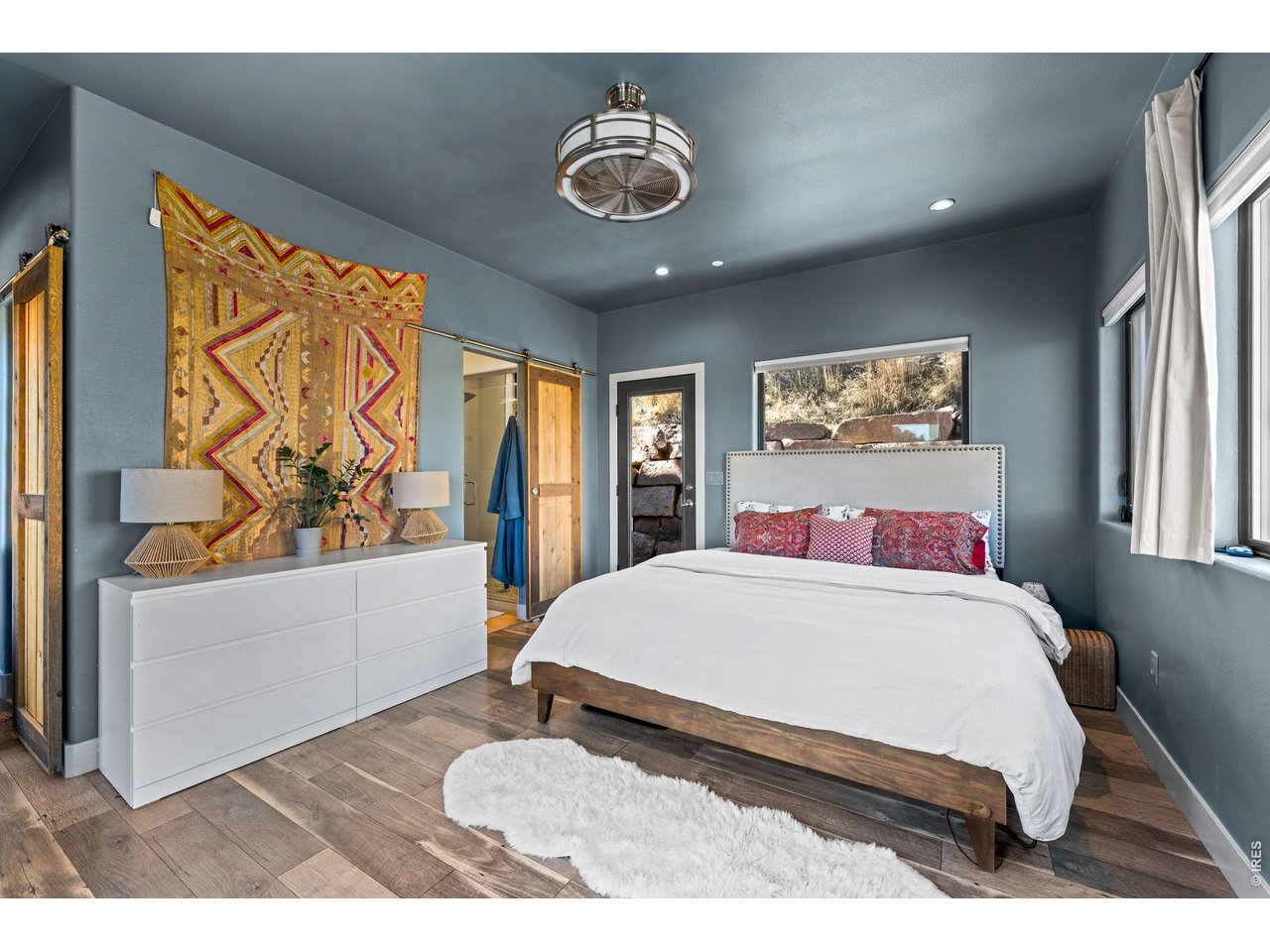 865 North Cedar Brook Road Boulder, CO 80304 - Photo 20 of 49 a bedroom with a large bed and a chandelier