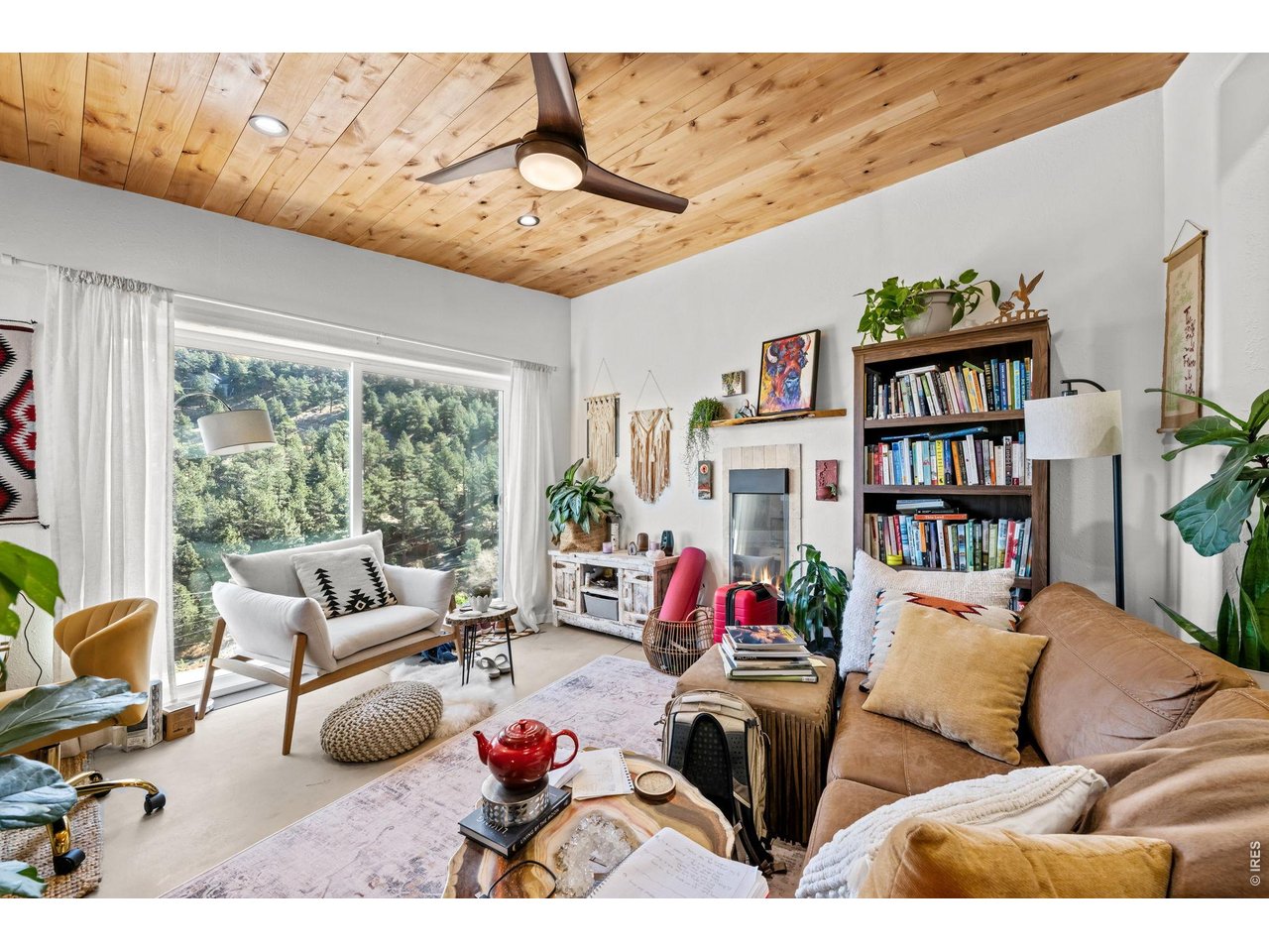865 North Cedar Brook Road Boulder, CO 80304 - Photo 34 of 49 a living room with furniture a bookshelf and a large window