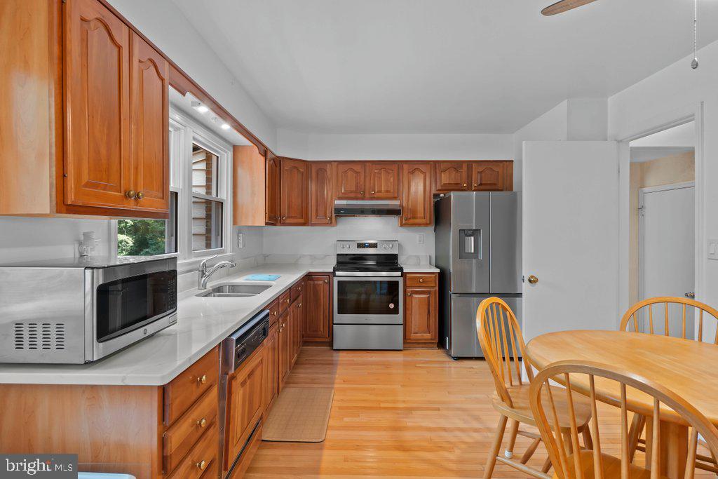 9704 Hall Road Potomac, MD 20854 - Photo 12 of 41 a kitchen with stainless steel appliances granite countertop a stove top oven a sink and dishwasher