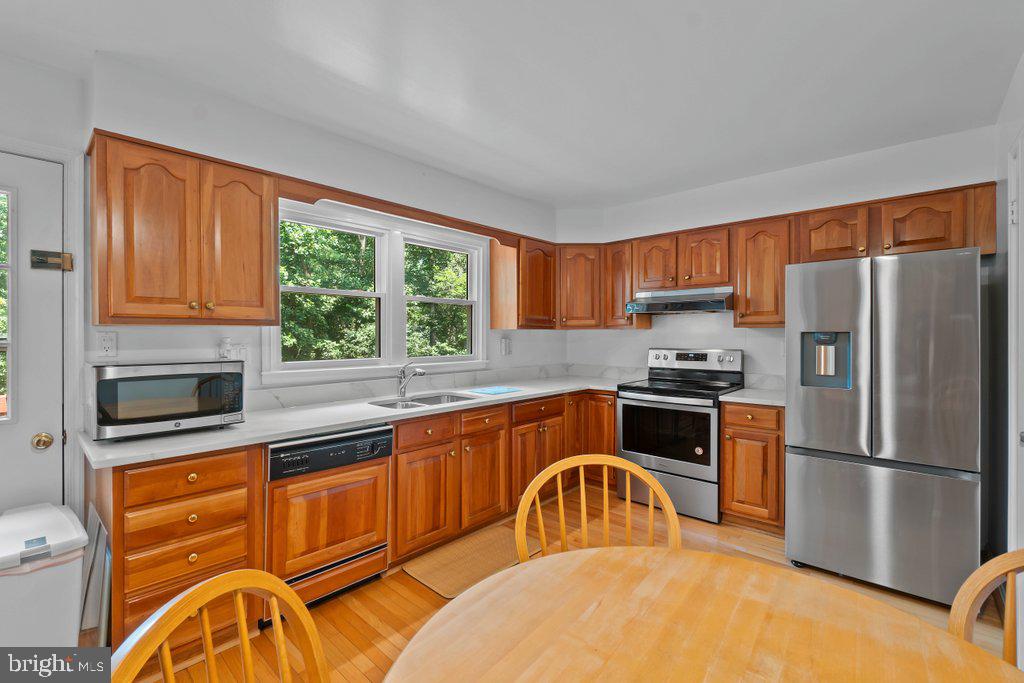 9704 Hall Road Potomac, MD 20854 - Photo 13 of 41 a kitchen with stainless steel appliances granite countertop a stove a sink and a refrigerator
