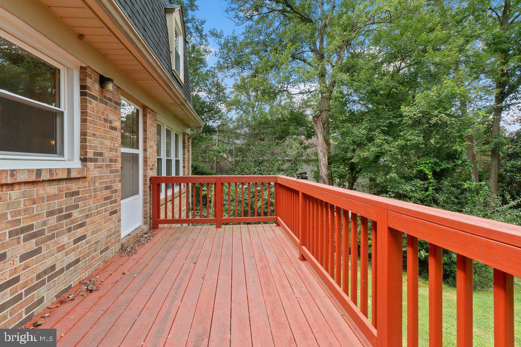 9704 Hall Road Potomac, MD 20854 - Photo 16 of 41 a balcony with wooden floor and trees in the back