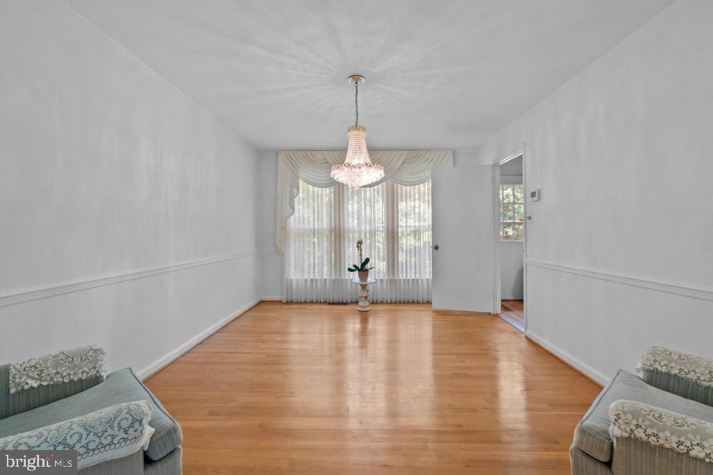9704 Hall Road Potomac, MD 20854 - Photo 10 of 41 a view of an empty room with chandelier fan and wooden floor