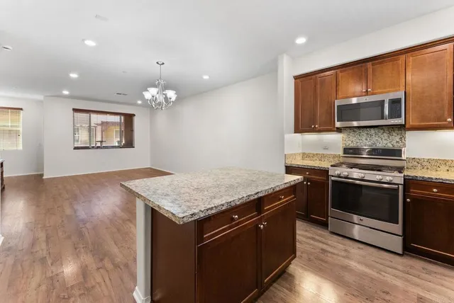 a kitchen with stainless steel appliances granite countertop a stove refrigerator and dishwasher