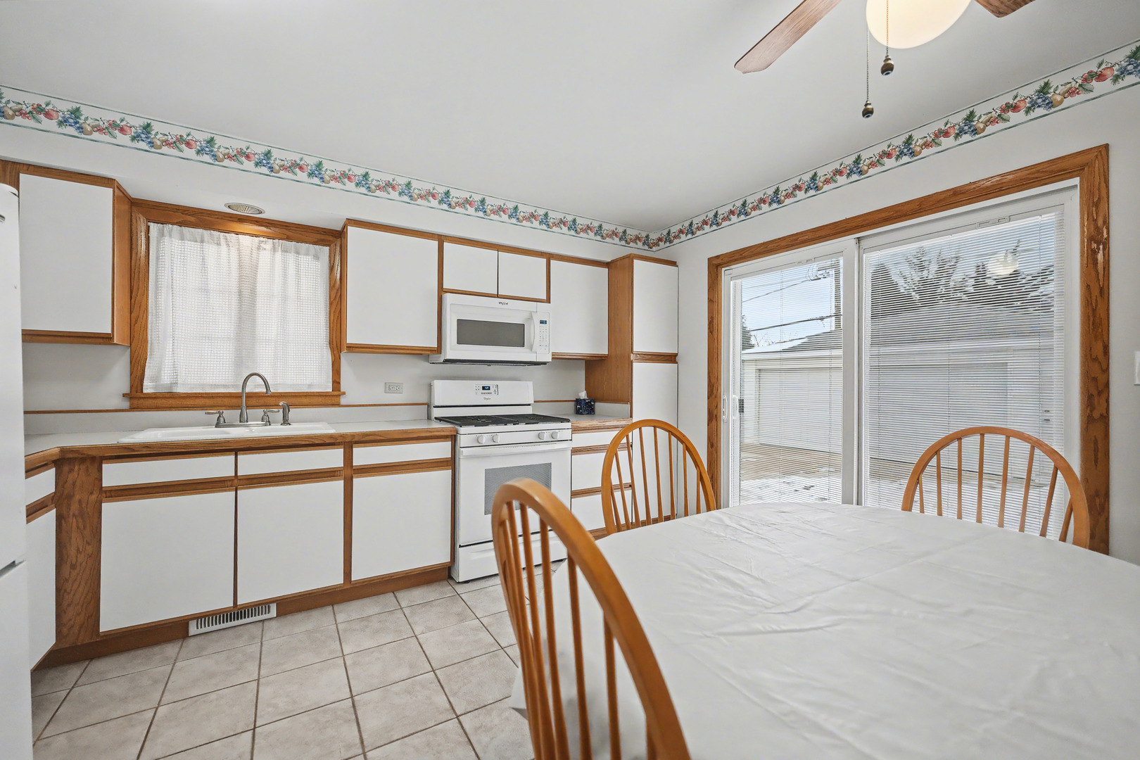 118 Evergreen Street Addison, IL 60101 - Photo 12 of 38 a kitchen with stainless steel appliances granite countertop a stove a sink dishwasher a microwave oven and a dining table with wooden cabinet