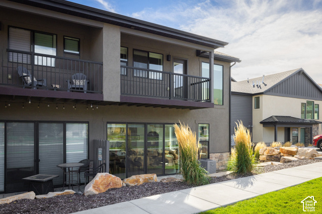 1141 520 West Midway, UT 84049 - Photo 31 of 40 Exterior featuring a stucco finish, stone accents, multiple balconies with metal railings, and ground-level patios with sliding glass doors