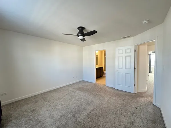 an empty room with closet and a ceiling fan