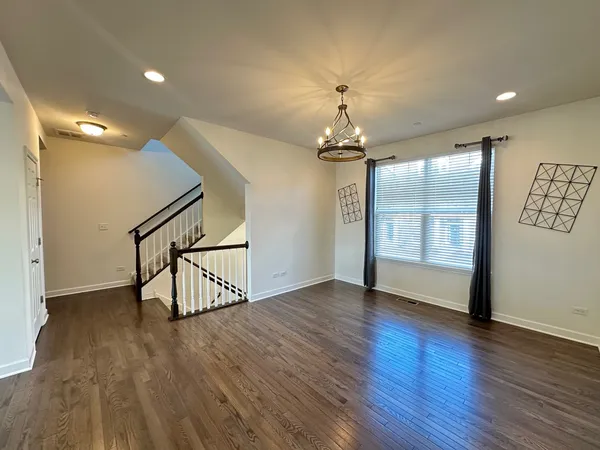 a view of an livingroom with wooden floor and stairs