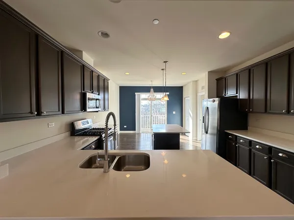 a large kitchen with kitchen island a sink stainless steel appliances and cabinets