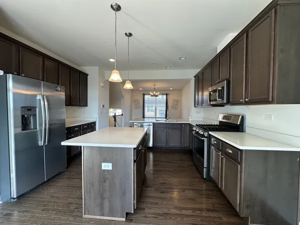 a kitchen with stainless steel appliances granite countertop a sink a stove and a refrigerator