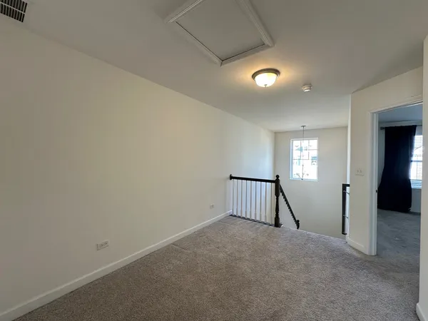 an empty room with staircase and mirror