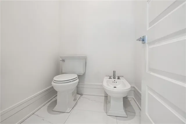 a bathroom with a toilet sink vanity and mirror