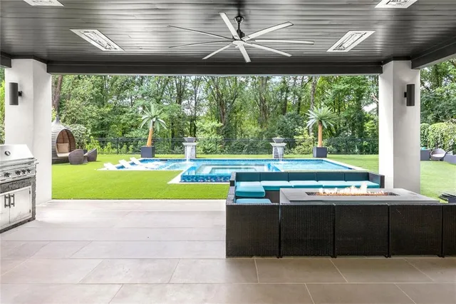 a living room with furniture large windows a flat tv screen and a table