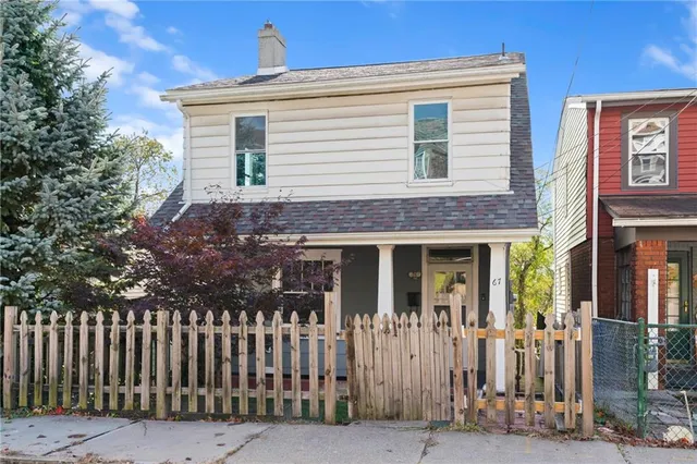 a front view of white house with a small yard