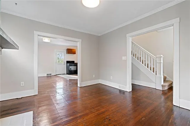 a view of a livingroom with wooden floor and a staircase