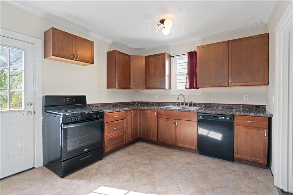 67 Semicir Street Pittsburgh, PA 15214 - Photo 14 of 36 a kitchen with granite countertop a stove top oven sink and cabinets