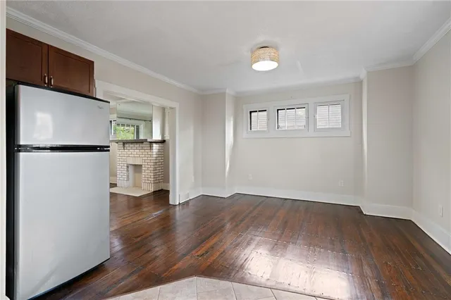 a view of empty room with kitchen and wooden floor