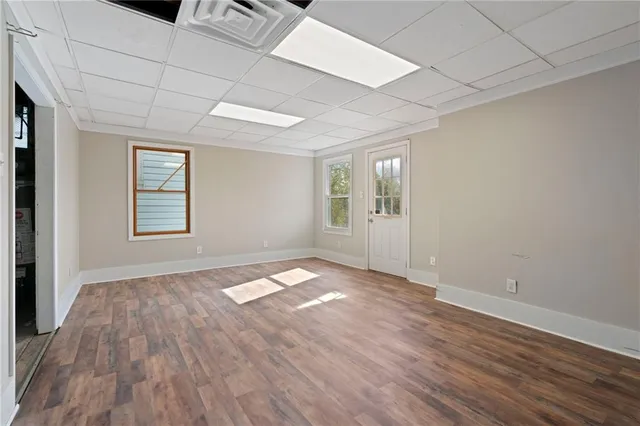 an empty room with wooden floor and windows