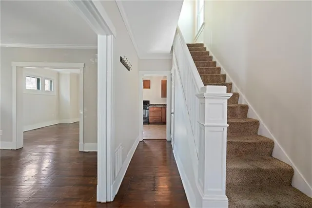 a view of a hallway with wooden floor and staircase
