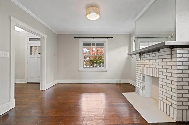 an empty room with windows and fireplace